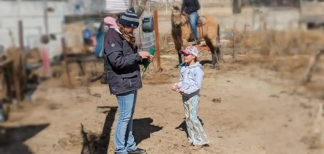 group-of-riders-and-instructors-gathered-in-an-arena-at-latigo-trails-equestrian-center