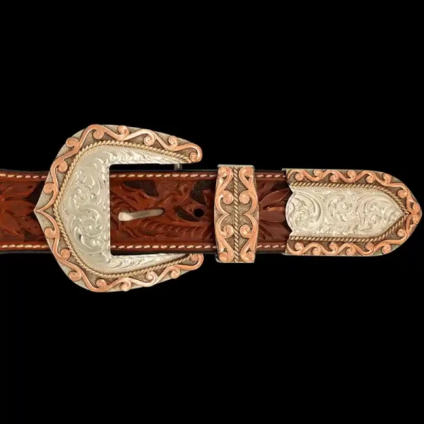 A custom western three piece belt buckle set featuring an engraved silver base with copper edge accents 