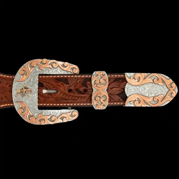 A custom western three piece belt buckle set featuring a cowboy figure and copper accents 
