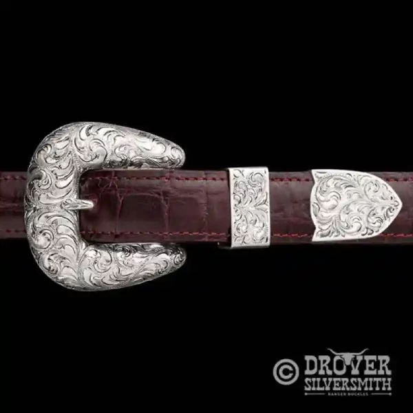 A sterling silver belt buckle set featuring a hand engraved buckle, loop and tip. 