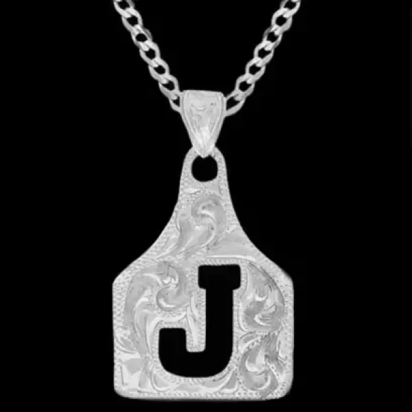 A silver cow tag necklace featuring a black initial and hand engraved base