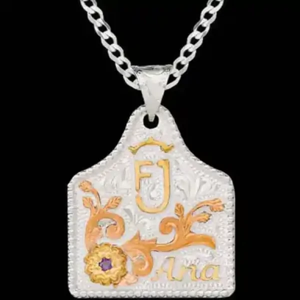 A silver plated cow tag necklace featuring a golden ranch brand, copper vines  and custom name 