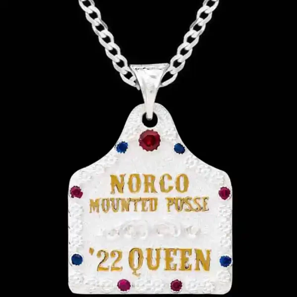 A silver plated cow tag necklace featuring golden lettering and zirconia stones 