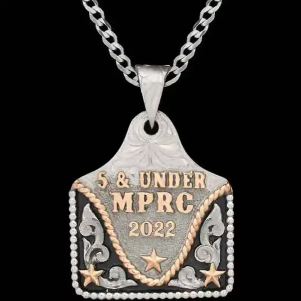 A  cow tag necklace featuring personalized golden lettering, stars and silver scrolls