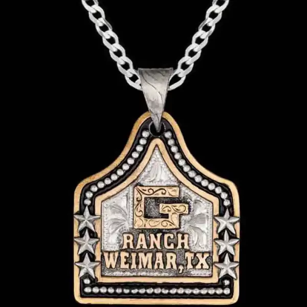 A cow tag necklace featuring bronze lettering, custom ranch brand and silver stars and beads