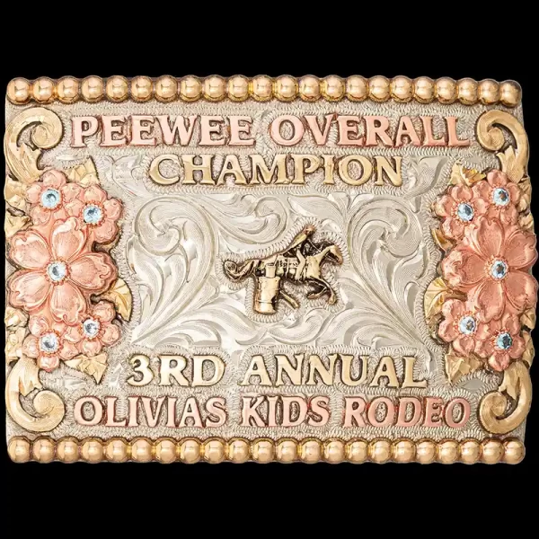 A custom women's belt buckle trophy for Olivias Kids Rodeo Peewee Overall Champion featuring a barrel racing cowgirl figure 