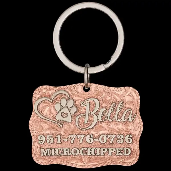 A custom dog tag with personalized engraved silver lettering built on a copper base, featuring a heart and a paw, western designed