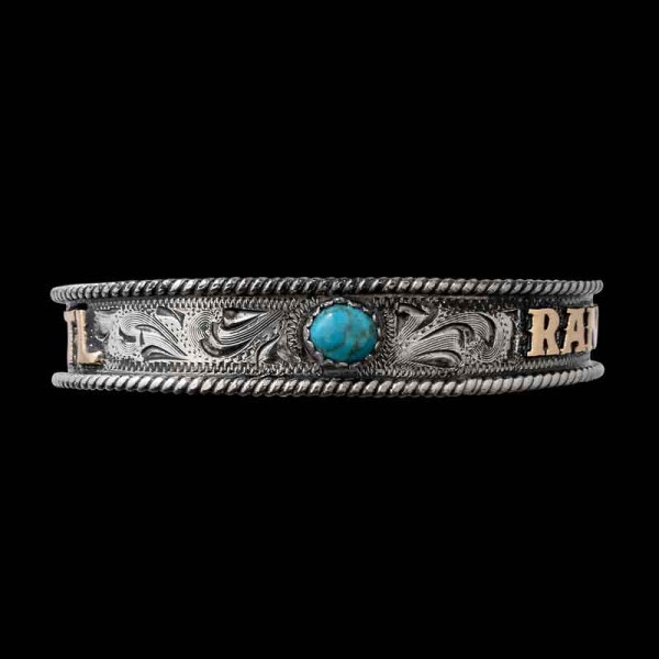 A silver cuff bracelet for men and women featuring a turquoise stone and personalized bronze lettering 