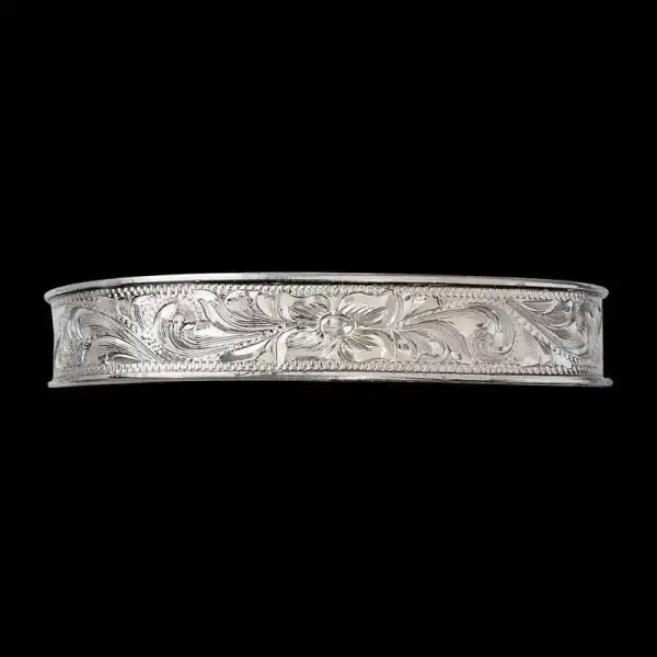A silver cuff bracelet for men and women featuring a hand engraved floral pattern