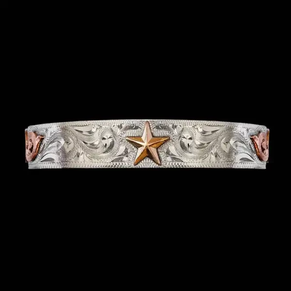 A silver cuff bracelet for men and women featuring a hand engraved pattern and a golden star figure 