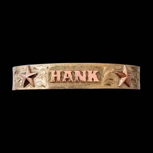 A golden cuff bracelet for men and women featuring golden star figures and personalized copper lettering 