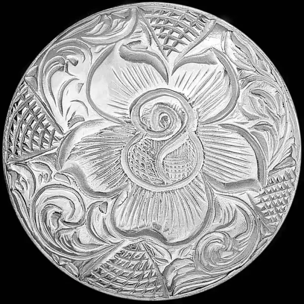 A hand engraved custom silver concho in natural finish featuring a rose figure 
