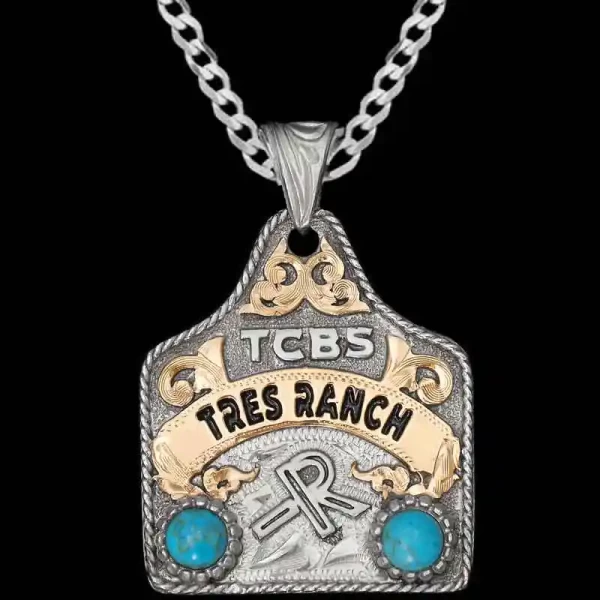 A cow tag necklace featuring personalized lettering, ranch brand and green zirconia stones