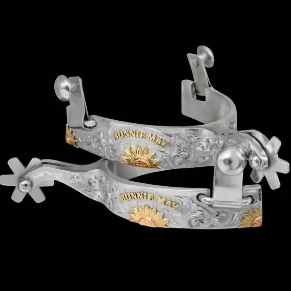 A custom pair of cowboy boot spurs with handmade details featuring personalized lettering and a sunflower figure