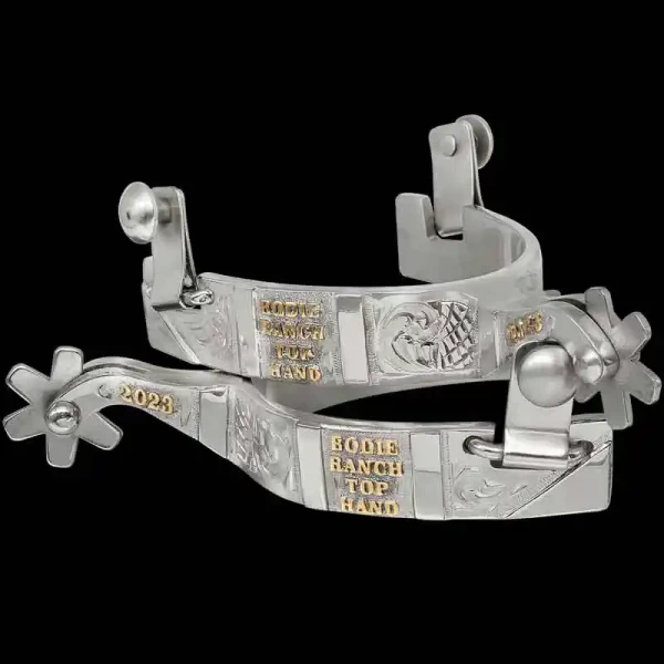 A custom pair of cowboy boot spurs with handmade details featuring personalized lettering 
