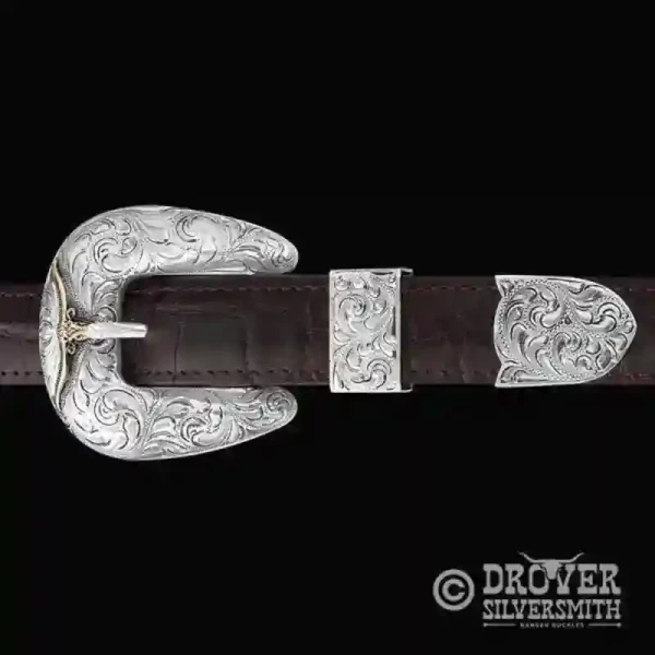 A sterling silver belt buckle set featuring 3d scrollwork and a custom zirconia stone. 
