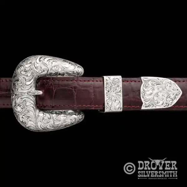 A sterling silver belt buckle set featuring a half hand engraved half 3d scrollwork on buckle, loop and tip.  