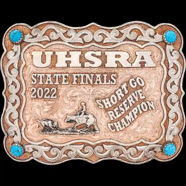 A custom copper rodeo belt buckle for women for UHSRA State Finals featuring a cutting cowgirl figure and turquoise stones 