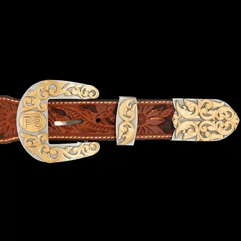 A custom western three piece belt buckle set featuring a personalized ranch brand and golden bronze scrollwork