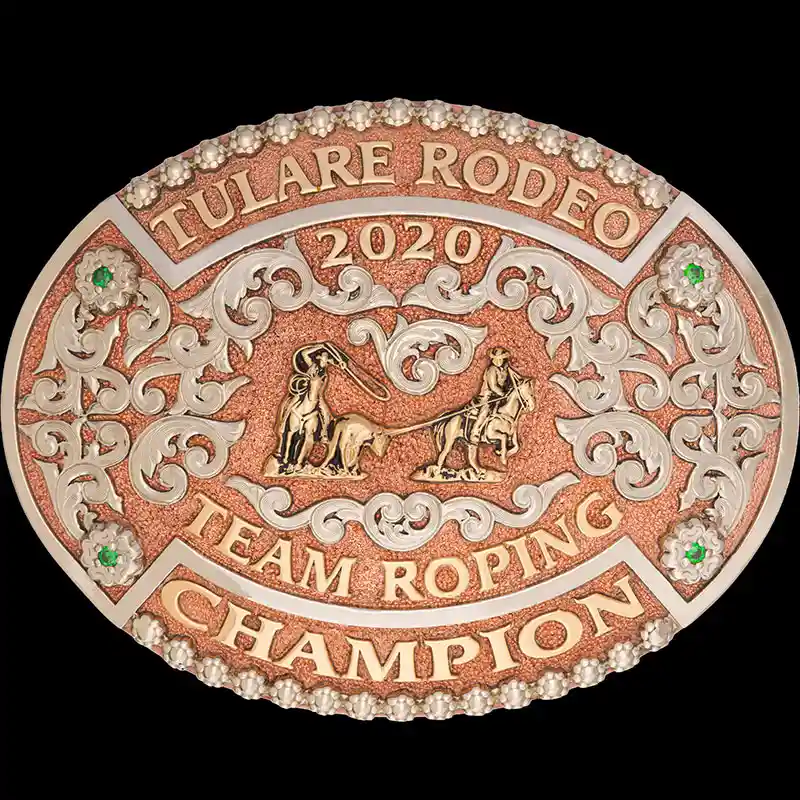 A custom oval rodeo belt buckle for Tulare Rodeo Team Roping Champion featuring a copper base and a team roper figure 