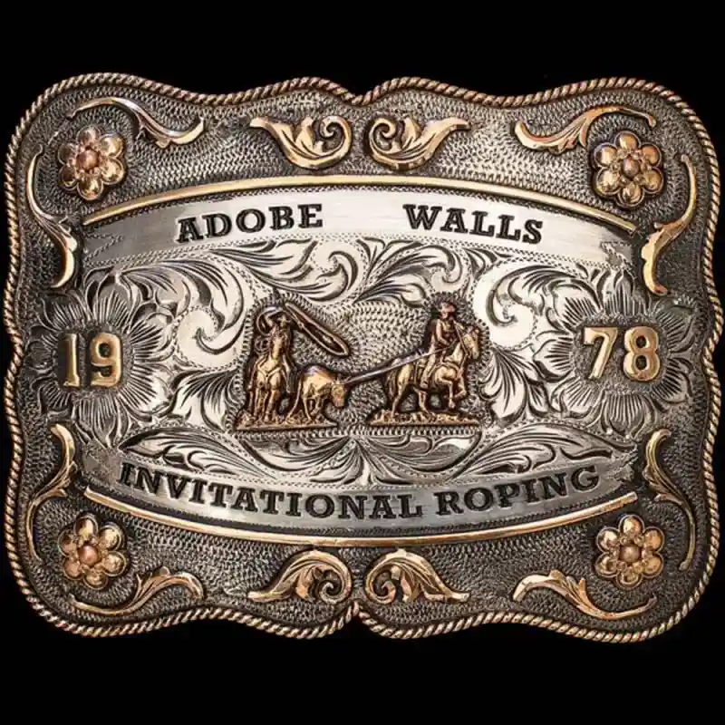 A custom rodeo belt buckle for Adobe Walls Invititational Roping featuring a team roping figure 