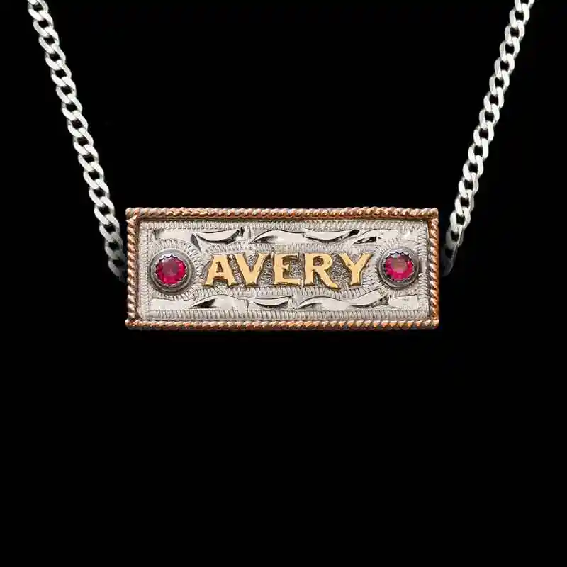 A custom name plate pendant necklace featuring personalized bronze lettering, with a sterling silver chain