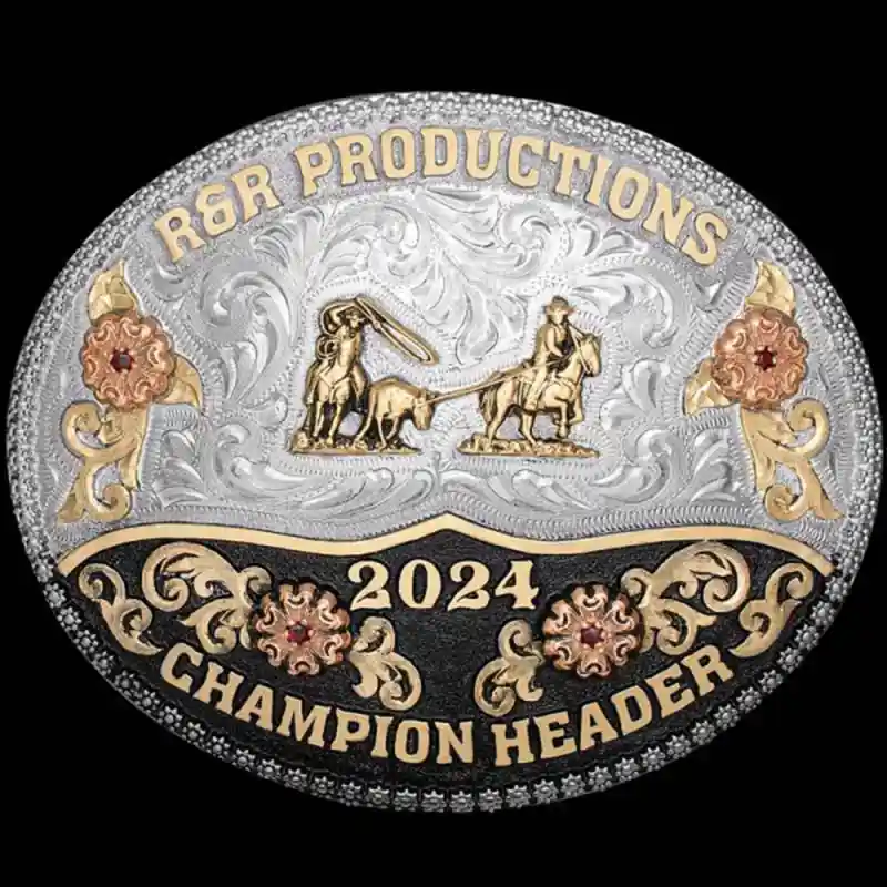 A custom oval rodeo belt buckle trophy for R&amp;R Productions Champion Header featuring a team roping figure 